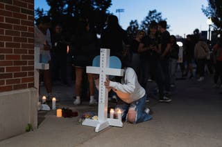 A mourner writes a message on a memorial cross following a prayer vigil at Academy of Holy Angels, following a shooting earlier in the day at Annunciation Church in Richfield, Minnesota, U.S. 27 August 2025